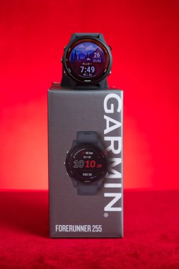 ZhongShan Çin-20 Mayıs 2025: Garmin Forerunner 255 dikey kompozisyonda kırmızı üzerine spor saati.