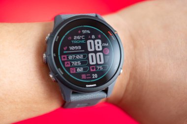 ZhongShan Çin-20 Mayıs 2025: Garmin Forerunner 255 spor saati ile yatay kompozisyon kırmızı üzerine.