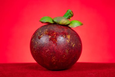 Yatay kompozisyonda kırmızı arkaplan üzerinde taze mangostee