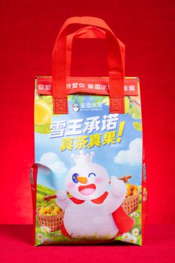 ZHONGSHAN GUANGDONG China-April 23,2023: pack of food or drink of Mixue on red at vertical composition.