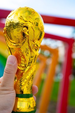 ZHONGSHAN Çin - 20 Haziran 2025: Açık havada bir Dünya Kupası kupa modelini dikey kompozisyonda tutan.