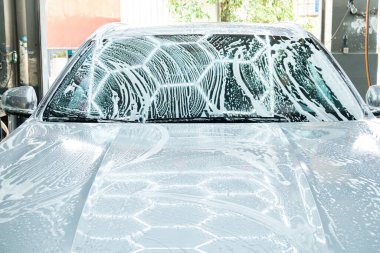 Bir arabayı yatay kompozisyonda sabunlu suyla yıkamak