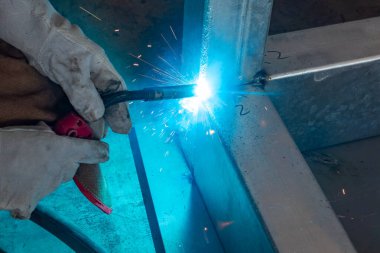 Yatay bileşimi olan bir fabrikada kaynak yapan işçiler.