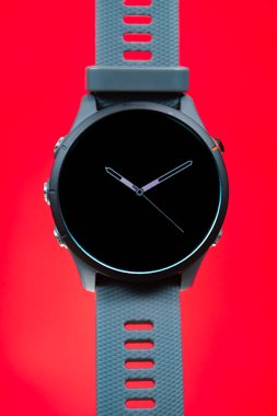 Dikey kompozisyonda kırmızı üzerine bir spor saati