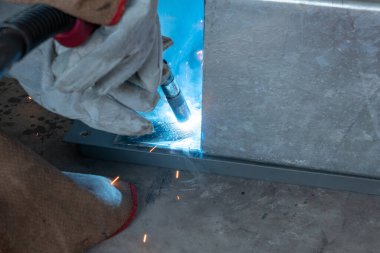 Yatay bileşimi olan bir fabrikada kaynak yapan işçiler.