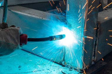 Yatay bileşimi olan bir fabrikada kaynak yapan işçiler.