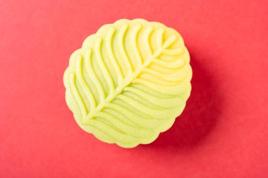 Üst manzara moda ve güzel yaprak şekilli kırmızı arka planda yeşil ay pastası