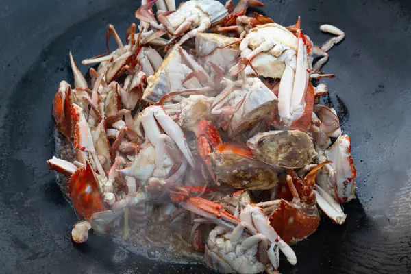 Büyük bir tavada ev usulü kızarmış yengeç.