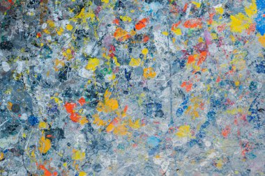 Değişken, soyut bir tuval rengarenk sıçramalarla ve katmanlı fırça darbeleriyle kasvetli mavi-gri zemin üzerinde patlıyor.