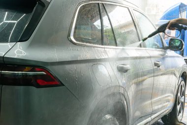 Bir arabayı yatay kompozisyonda suyla yıkamak