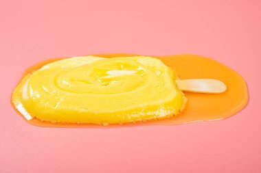 Pembe arka planda erime sürecinde sarı buzlu şeker