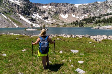 Yalnız Göl 'de sırık kullanan bir kadın yürüyüşçü, Grand Teton Ulusal Parkı Wyoming' de 17 millik yürüyüş.