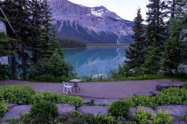 Britanya Kolumbiyası Kanada 'daki Emerald Gölü' nde gün batımında bir terasta tek masa ve sandalye