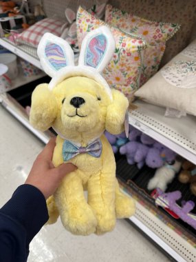 Maple Grove, Minnesota - 8 Nisan 2023: FAO Schwartz sarı labrador av köpeği pelüş pelüş hayvanı, Paskalya bayramında tavşan kulağı takarak bir Target mağazasında satılıyor.
