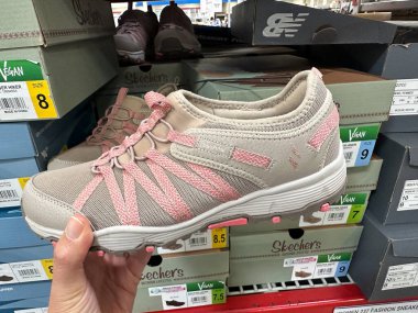 Maple Grove, Minnesota - 8 Nisan 2023: Hand, Sams Club 'da satılık bir çift Skechers marka vegan yürüyüş ayakkabısı tutuyor
