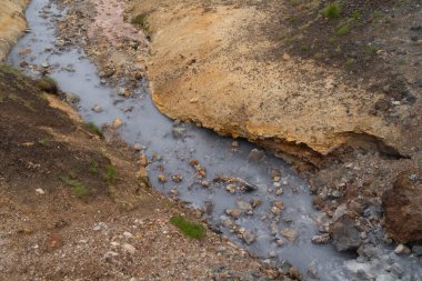 İzlanda 'daki Seltun Jeotermal Bölgesi' nde tehlikeli bir sıcak kaynak suyu ve kayalara yakın.