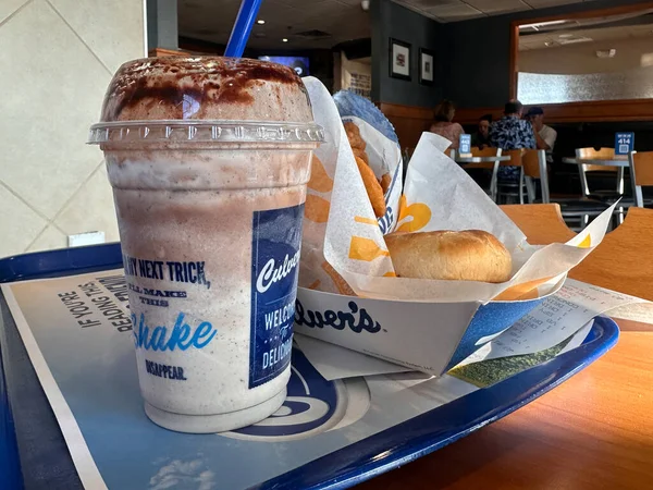 Baldwin, Wisconsin - 21 Temmuz 2023: Çikolatalı milkshake ve Culvers fast food restoranındaki tepside bir hamburger sepeti