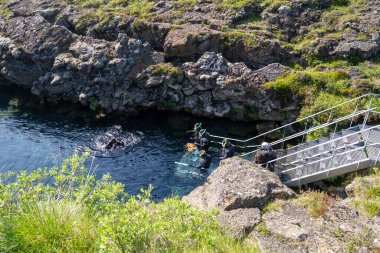 Thingvellir Ulusal Parkı, İzlanda - 9 Temmuz 2023: Turistler soğuk suya girmek için iki tektonik levha arasında şnorkelle yüzmeye hazırlanıyorlar