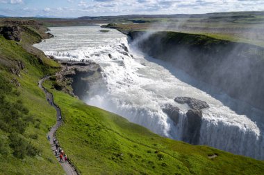 Gullfoss Şelalesi. Yaz boyunca İzlanda 'da çeşitli manzaralara giden yollar. Yoğun turist kalabalığı
