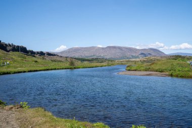 Güneşli bir günde İzlanda 'daki Thingvellir Milli Parkı' ndan geçen geniş bir nehir.