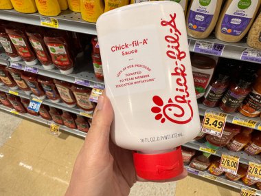 Viyana, Virginia - 13 Kasım 2023: Hand bir markette satılık bir şişe Chick-Fil-A tavuk sosu tutuyor