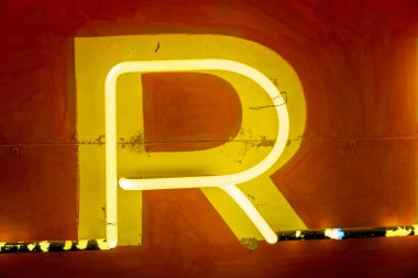 Neon sarısı R harfi gece bir tabelada aydınlandı.