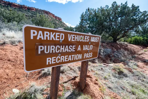 stock image Sign posted on a Sedona hiking trail - parked vehicles must purchase a valid pass