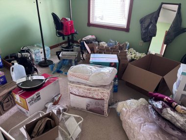 Scandia, Minnesota - 15 Mart 2024: Giysi ve diğer eşyaların tamamı, bir odada açık kutular. Aşırı paketleme, taşınma ya da istifleme kavramı