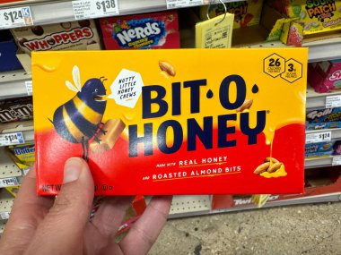 Temple, Teksas - 26 Haziran 2024 El, bir markette bir kutu Bit O Bal şekeri çiğniyor.
