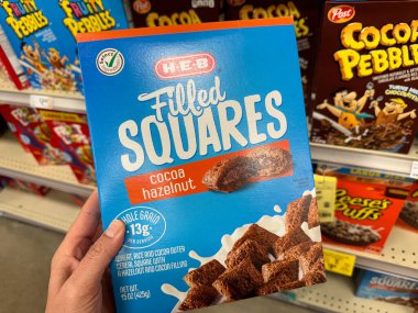 Temple, Texas - 26 Haziran 2024: Hand 'in elinde bir kutu HEB marka fındıklı gevrek kutusu var