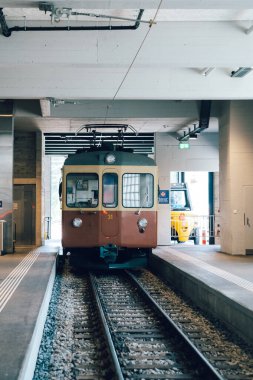 Murren, Switzerland - July 23, 2024: Murren railway train station, with its vintage   train cars at the Lauterbrunnen-Murren Mountain Railway clipart