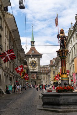 Bern, Switzerland - July 22, 2024: Zahringerbrunnen fountain features the city founder and a bear, standing with a flag in the crowded Marktgasse, one of the main streets in Bern clipart