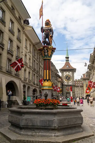 Bern, İsviçre - 22 Temmuz 2024: Zahringerbrunnen çeşmesinde, Bern 'in ana caddelerinden biri olan kalabalık Marktgasse' de bir bayrak taşıyan şehir kurucusu ve bir ayı görülüyor.