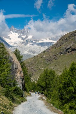 Zermatt, Switzerland - July 27, 2024: Hikers on the Five Lakes Trail in Zermatt Switzerland, views of the Matterhorn in distance clipart