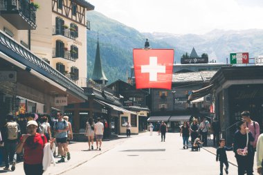 Zermatt, İsviçre - 19 Şubat 2024: Zermatt 'taki arabasız kayak köyünde Bahnhofstrasse' nin yaya alışveriş caddesi. Valais Kantonu, İsviçre