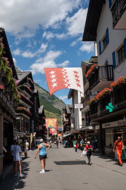 Zermatt, İsviçre - 19 Şubat 2024: Zermatt 'taki arabasız kayak köyünde Bahnhofstrasse' nin yaya alışveriş caddesi. Valais Kantonu, İsviçre