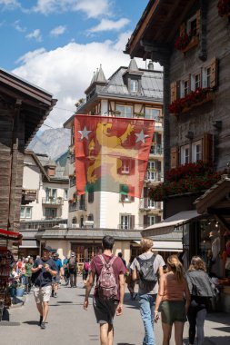 Zermatt, İsviçre - 19 Şubat 2024: Zermatt 'taki arabasız kayak köyünde Bahnhofstrasse' nin yaya alışveriş caddesi. Valais Kantonu, İsviçre