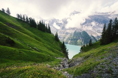 İsviçre 'deki Oeschinensee Gölü yürüyüşü sahnesi, İsviçre Alpleri' ndeki Kandersteg yakınlarında, çok kayalık bir arazi.