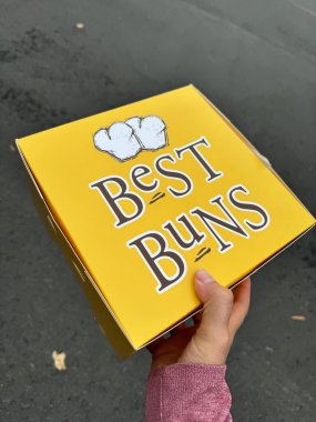 Vienna, Virginia - September 22, 2024: Hand holds a bakery box from Best Buns, a local restaurant chain clipart