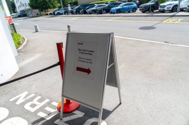 Kriens, Switzerland - July 19, 2024: Sign directing passengers to the bus stop to go to Lucerne, when doing the Golden Round Trip to Mt Pilatus clipart