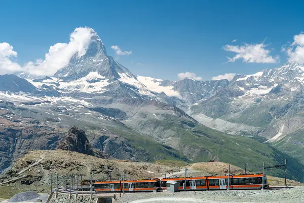 Gornergrat, İsviçre - 26 Temmuz 2024: Uzaktaki Matterhorn manzaralı Gornergrat tren istasyonunda yaz manzarası