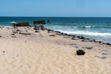 Cape Hatteras, Kuzey Carolina - 31 Ağustos 2024: Atlantik Okyanusu 'ndaki yüzücüler Cape Hatteras Ulusal Deniz Kıyısı' ndaki eski paslı bir balıkçı iskelesinin yakınında yüzüyorlar.