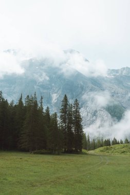 Clouds surround mountains near Oeschinensee Lake hike in Switzerland, near Kandersteg in the Swiss Alps clipart