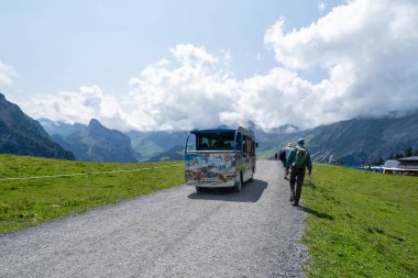 Kandersteg, Switzerland - July 24, 2024: Lake Oeschinensee electric shuttle bus takes visitors to the lake from the chairlift tram station clipart