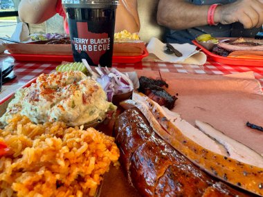 Waco, Texas - November 11, 2024: Plate of BBQ meat and sides at Terry Black's BBQ restaurant clipart