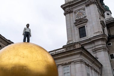 Salzburg, Avusturya - 28 Kasım 2024: Salzburg 'daki Kapitelplatz' da ünlü Paul Fuerst Sphere. Üzerinde Mozart şekerlerini temsil eden büyük altın bir Goldkugel topu.