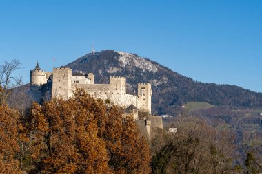 Fortress Hohensalzburg against a bright blue winter sky in the sunshine, on a hill. Salzburg Austria clipart