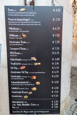 Salzburg, Avusturya - 28 Kasım 2024: Bosna, körili sosis ve şnitzel gibi geleneksel yiyecekler satan bir Noel pazarında menü