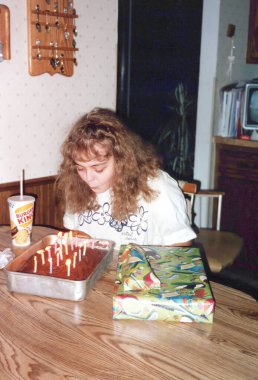 1996 - Minnesota: Genç kız doğum günü pastasında mumları doğum günü hediyeleriyle üflüyor. Görüntü klasik bir taramadır ve kusurları olabilir