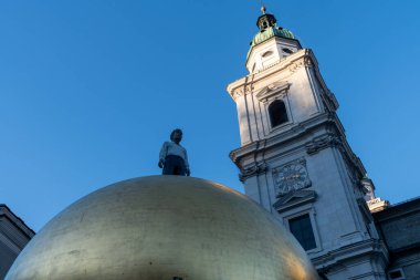 Salzburg, Avusturya - 28 Kasım 2024: Salzburg 'daki Kapitelplatz' da ünlü Paul Fuerst Sphere. Üzerinde Mozart şekerlerini temsil eden büyük altın bir Goldkugel topu.
